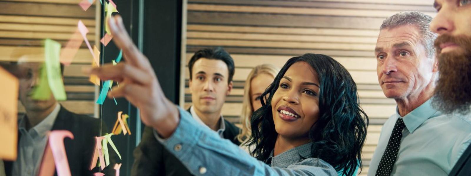 Group of people working together at a board.