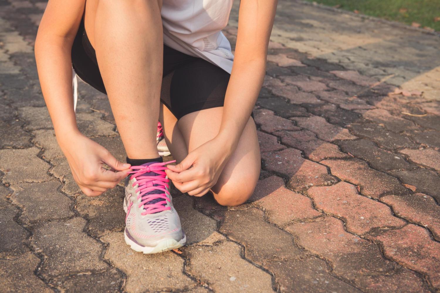female tying a running shoe