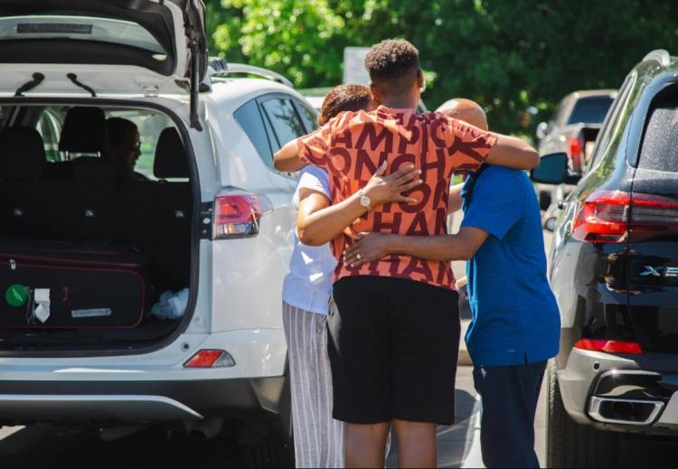 student hugging parents