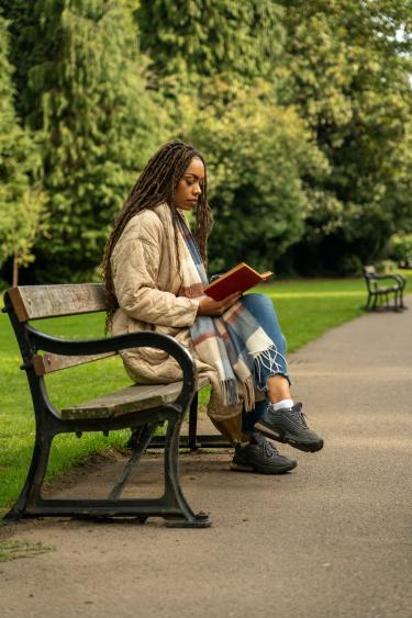 woman reading on park bench