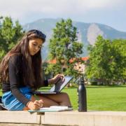 female student studying on farrand field