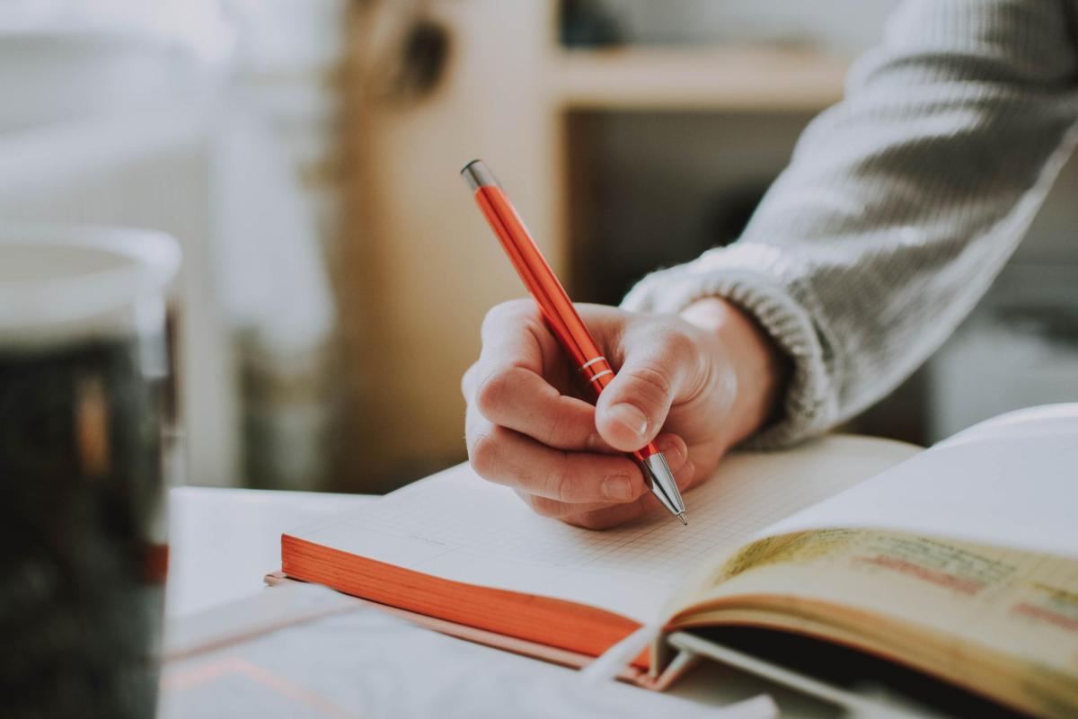 A person writing in a notebook.