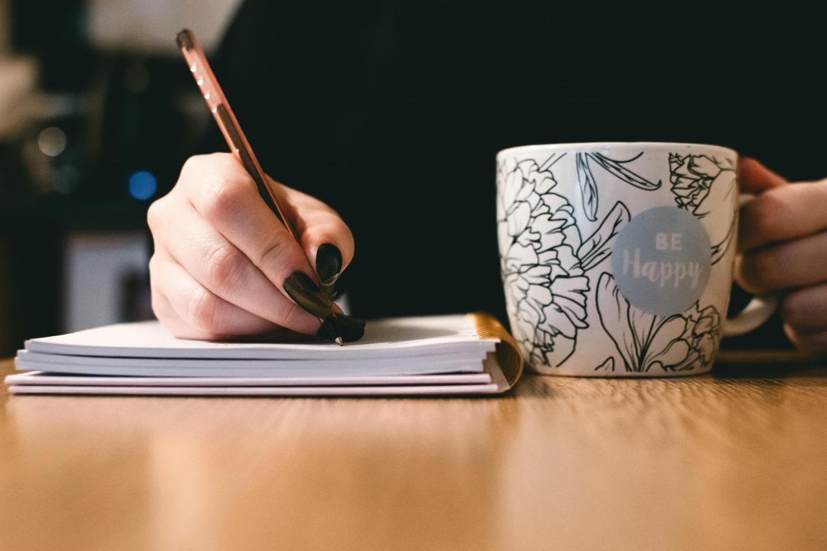 Woman writing with cup