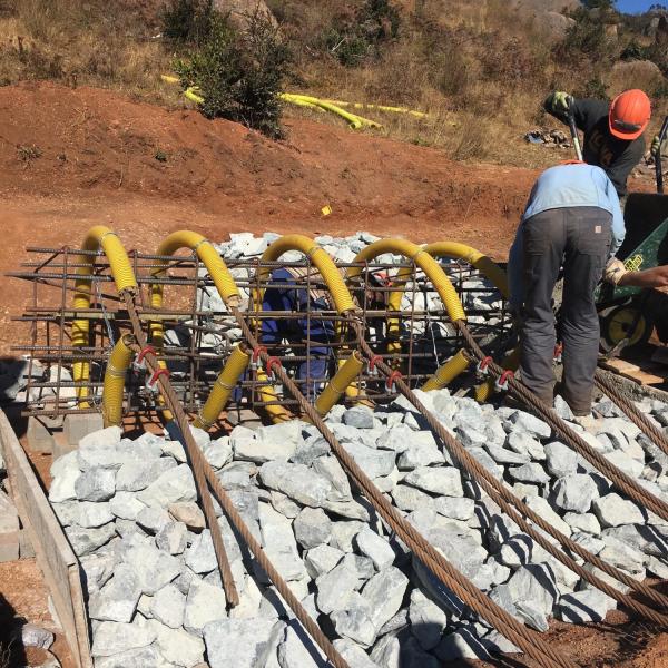 Laying cable within foundation cage