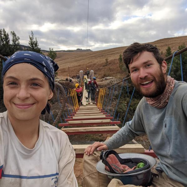 Members eating in front of almost completed bridge