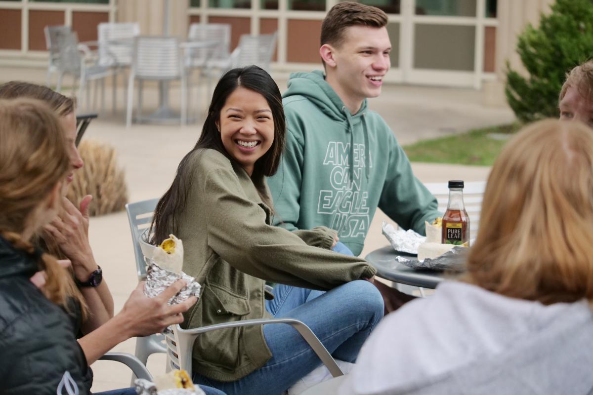 Students laugh as they eat lunch together