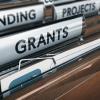 A collection of folders with labels. A label on the front folder reads "Grants".