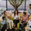 A group of coworkers gather around each other and discuss a book