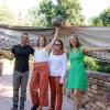three people stand in front of a giant fake bird