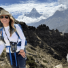 Joanna Lambert poses on Mount Everest with the Ama Dablam peak in the distance
