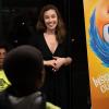A woman stands next to a banner with characters from Disney Pixar's "Inside Out" while talking to an audience on boys and girls club members