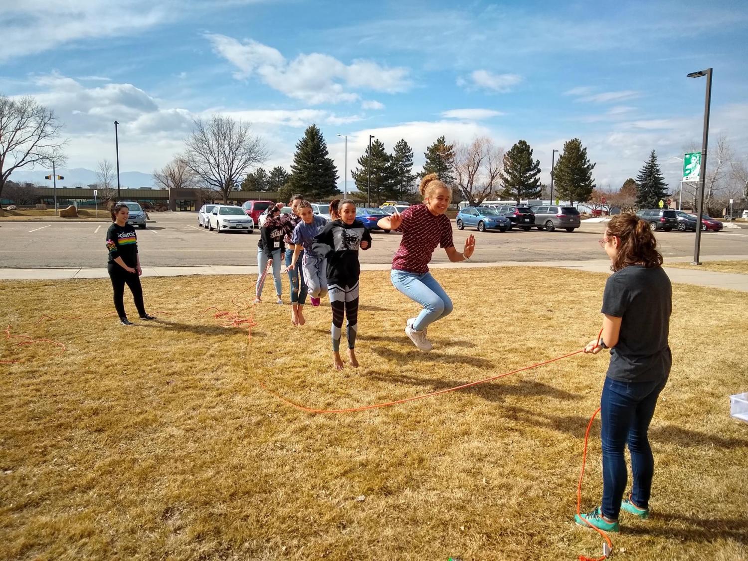 group of kids outside jumping rope with an extension cord