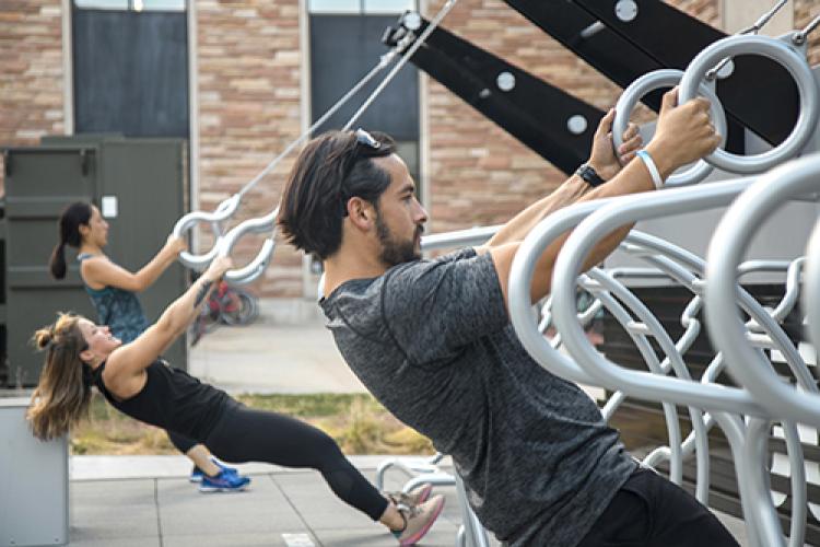 Students working out on outdoor fitness equipment