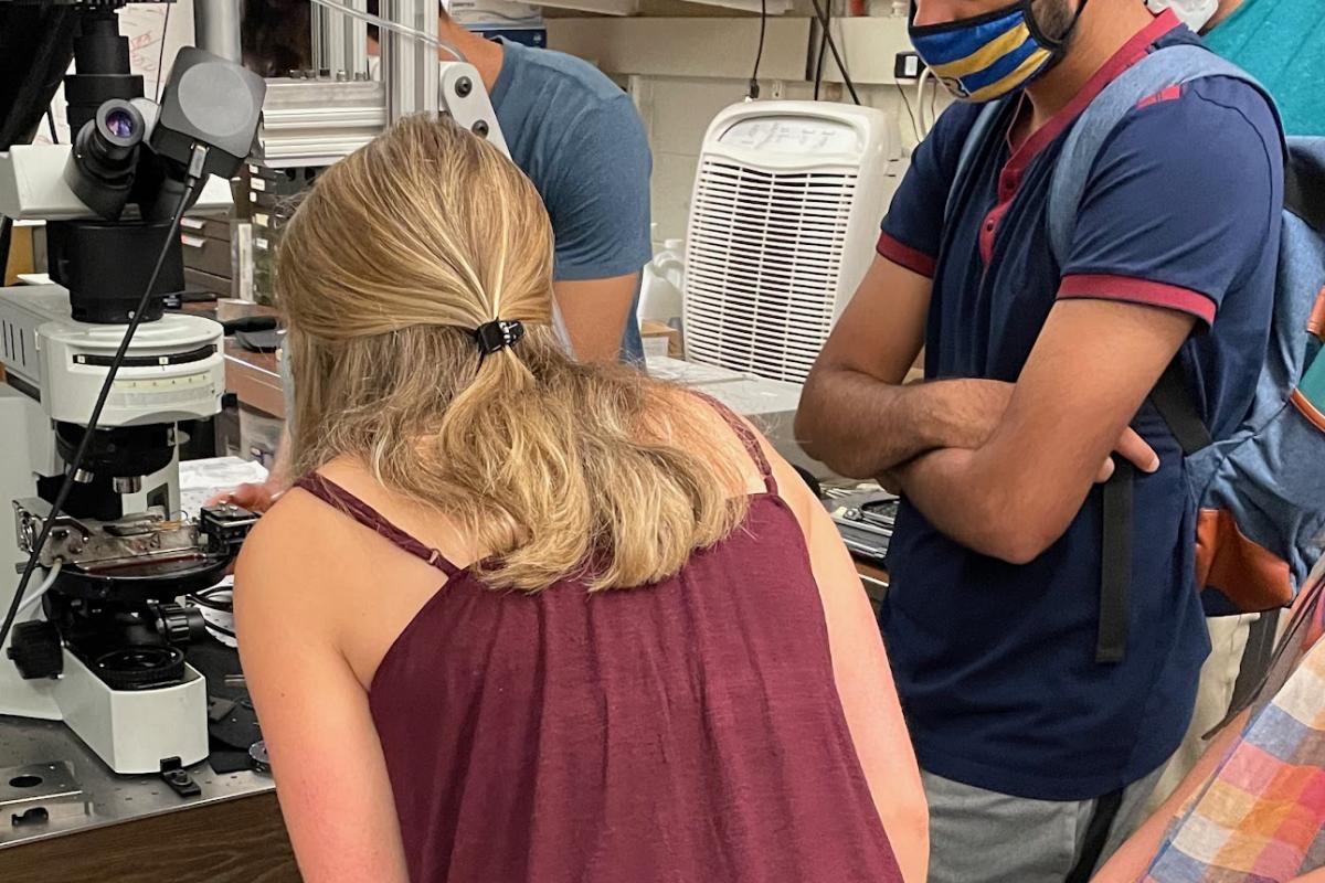 Students inspect a microscope