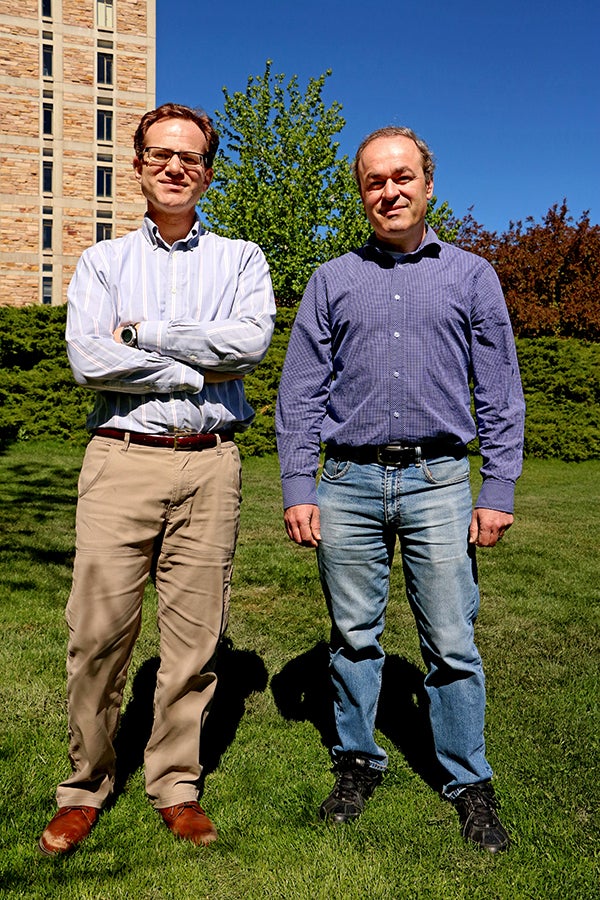 Portrait of Michael Hermele (Left) and Victor Gurarie (Right) standing in front of the JILA Tower.