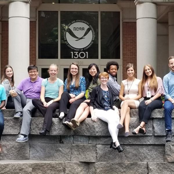 NOAA interns pose for a photo in front of a buliding