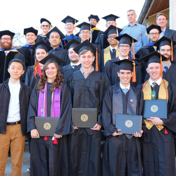 Group photo of graduating class and faculty on steps outside of Duane physics.