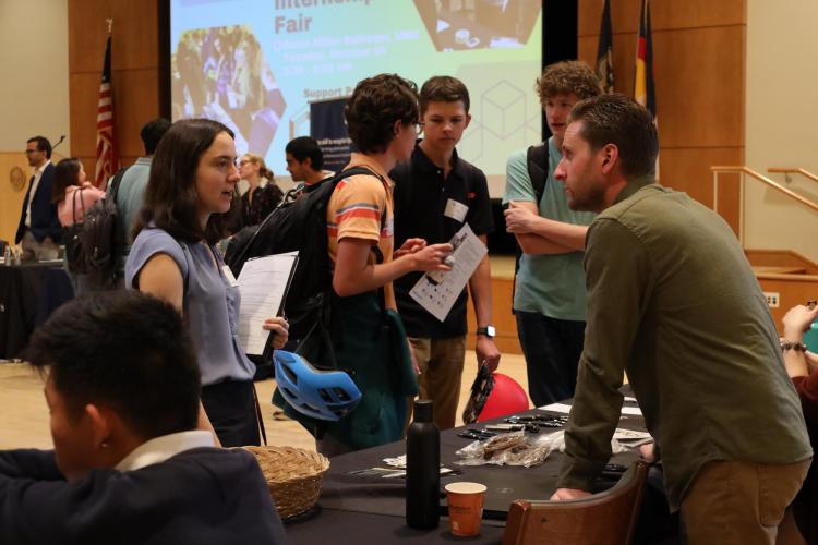Students are pictured talking with employers at tables
