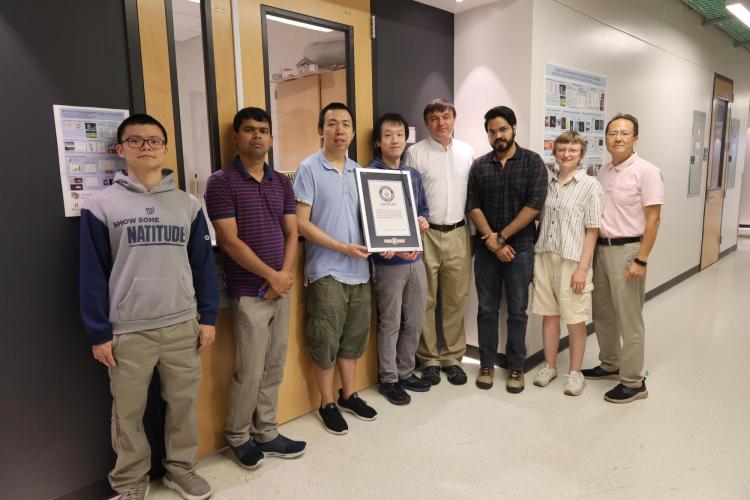 The Smalyukh group holding a plaque in front of the lab