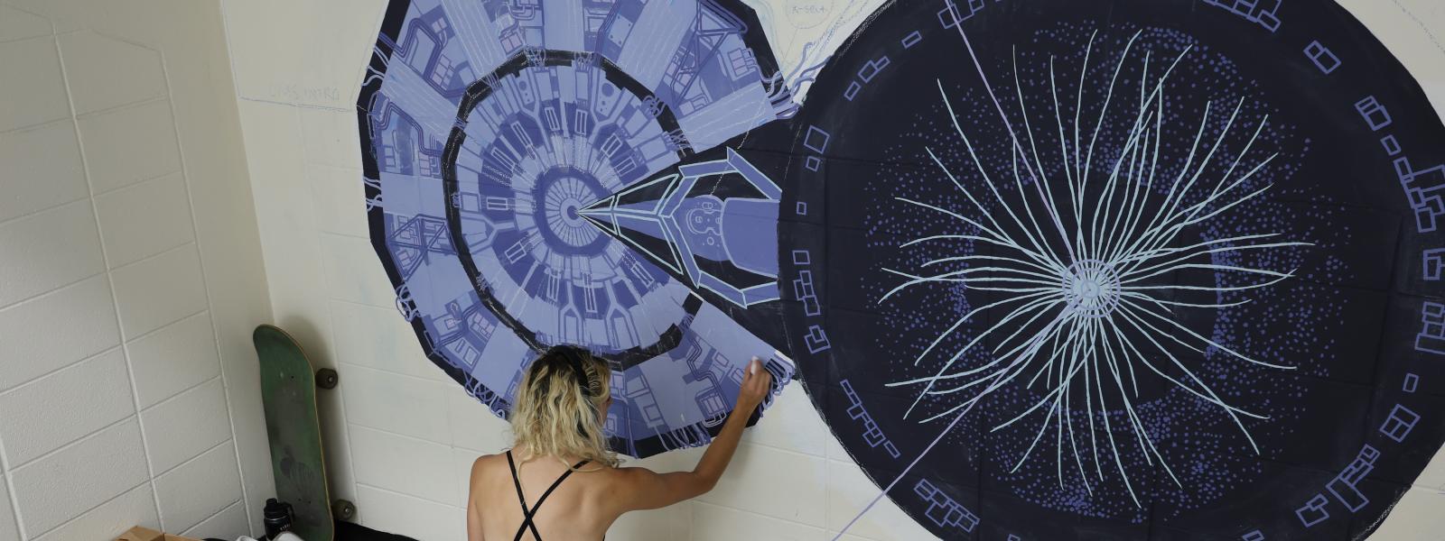 Veronica Keff painting a mural