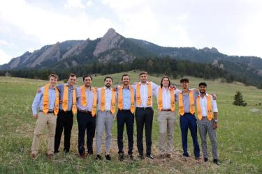 Group of students with stoles in front of the flat irons