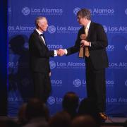 Gary Wall accepts a medal from Los Alamos director Thom Mason