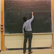 Eric Cornell writes on the chalkboard during a physics class