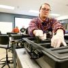 Student Hannah Scarbrough takes inventory of mechanical and optical kit components used in for experiments during a Quality Assurance of Precision Optics class