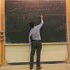 Eric Cornell writes on the chalkboard during a physics class