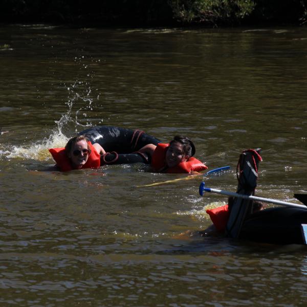 PLC students swim for the other side of the pond after their makeshift raft fails to hold them above water