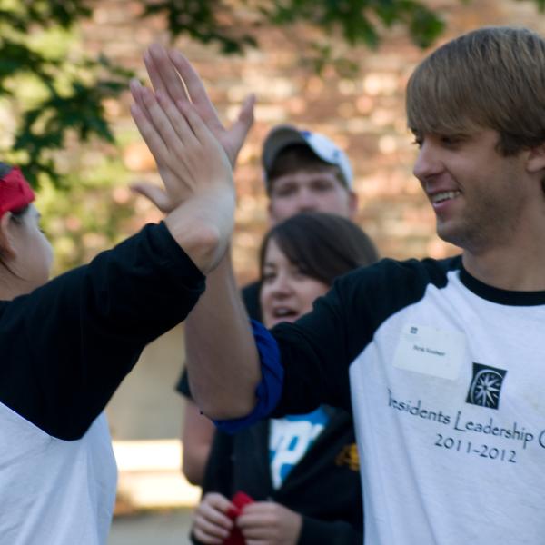 Jamie Gay and Derek Kessinger high five as group leaders for their orientation group