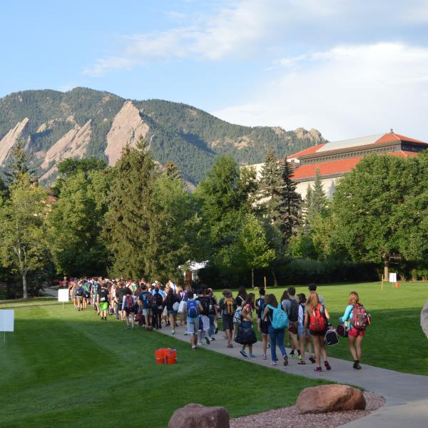 Students walk through the Norlin Quad to get to the buses that will take them to orientation