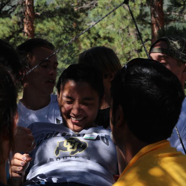 PLCer Martin Garcia winces as he tries to avoid touching the spider web in a low ropes initiative