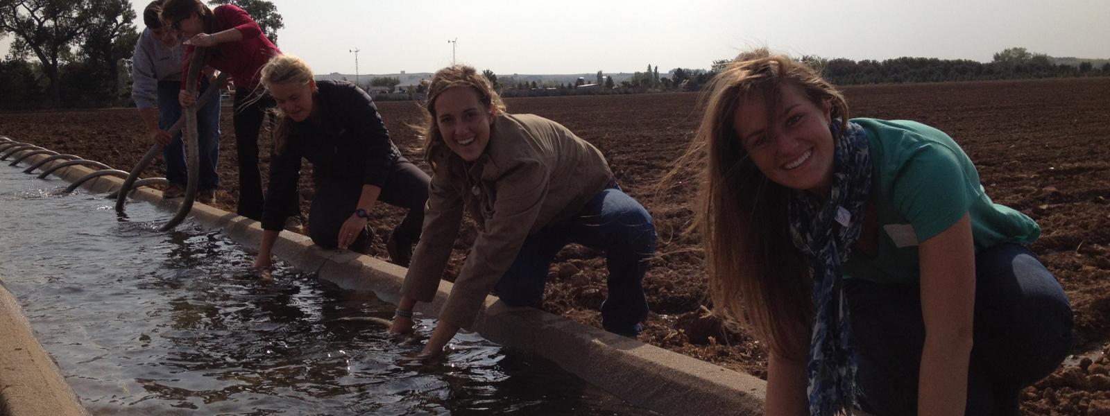 PLC students working with an irrigation ditch which is full of water