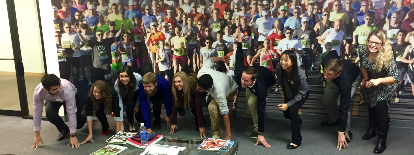 PLC students take their mark in front of a Bolder Boulder mural at the Bolder Boulder headquarters during Sports Tourism Weekend