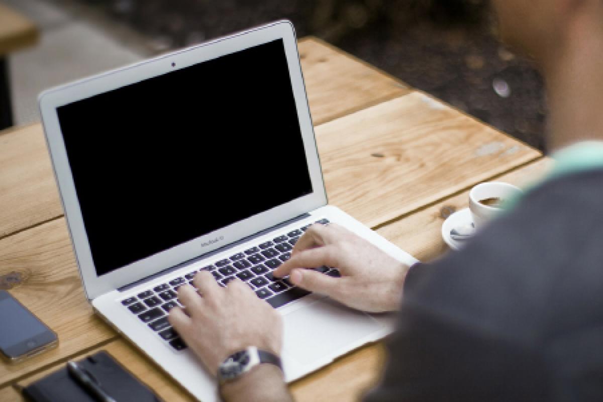A man typing on a laptop