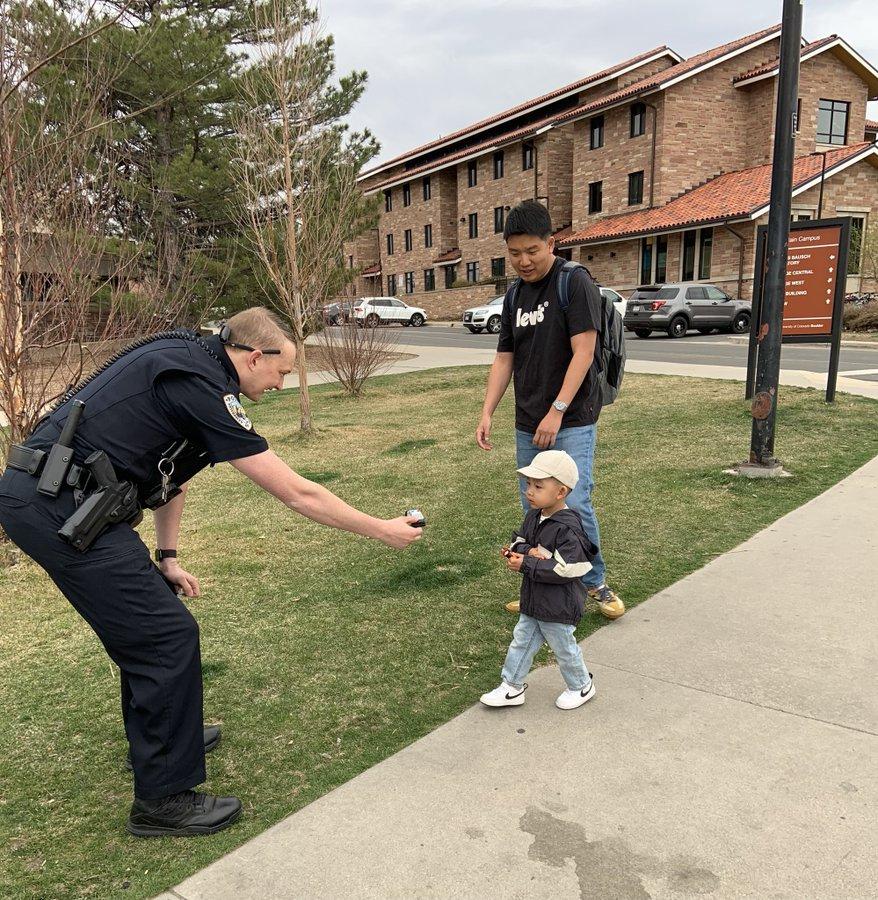CUPD Officers hands child a sticker