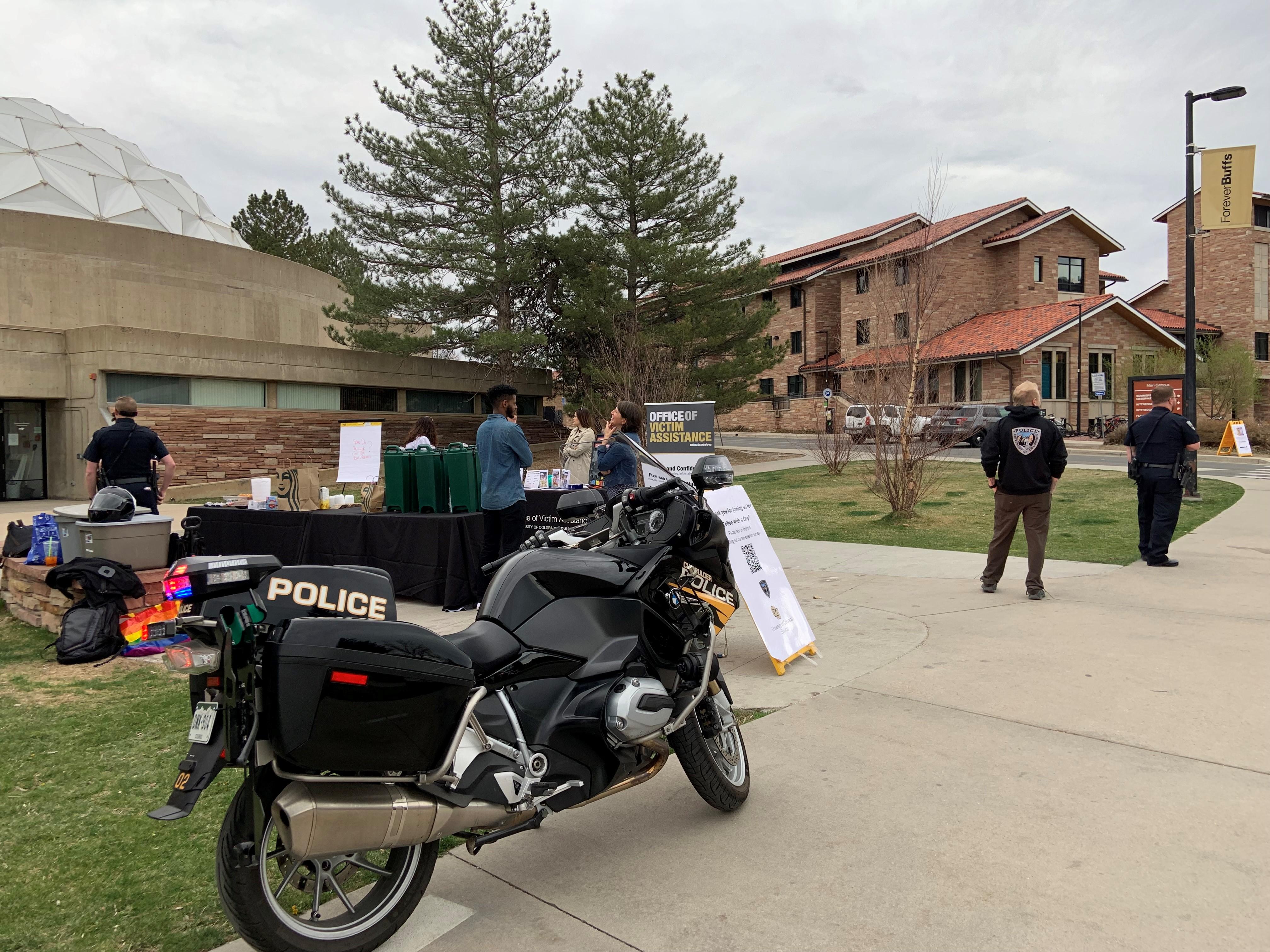 A CUPD motorcycle in the foreground of a Coffee with a Cop event