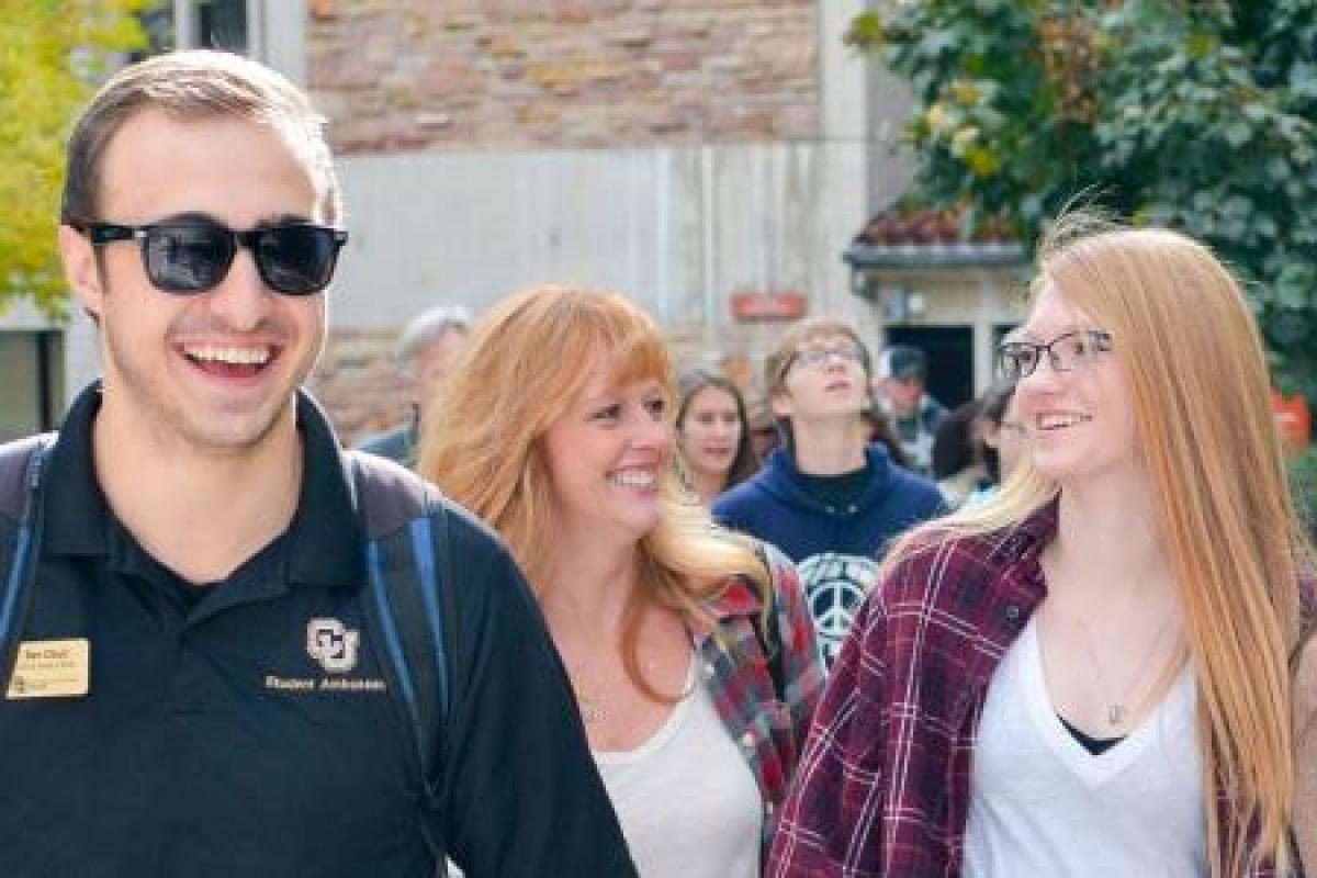 a campus tour guide laughing with prospective students