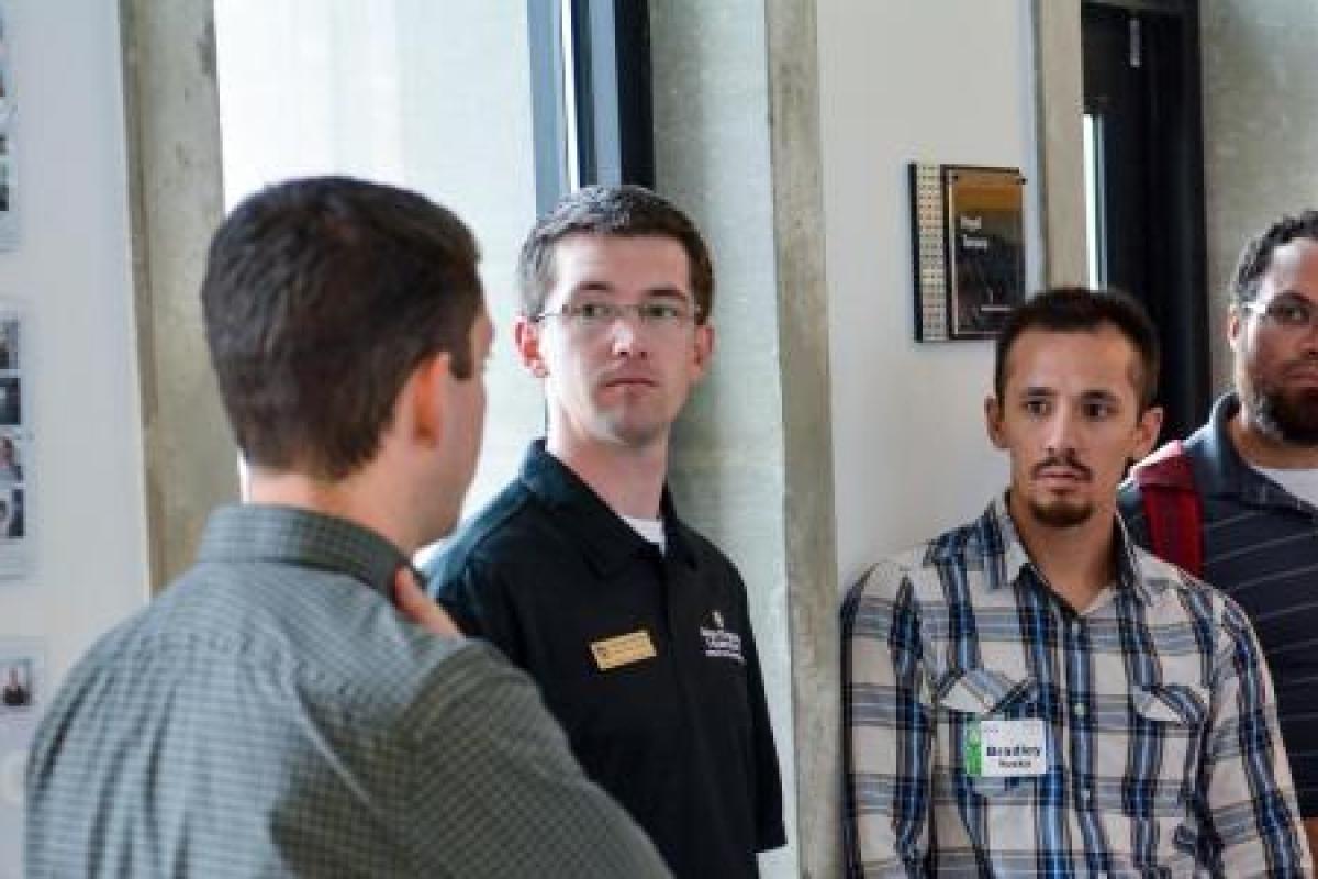 a campus tour guide talking with students in a hallway