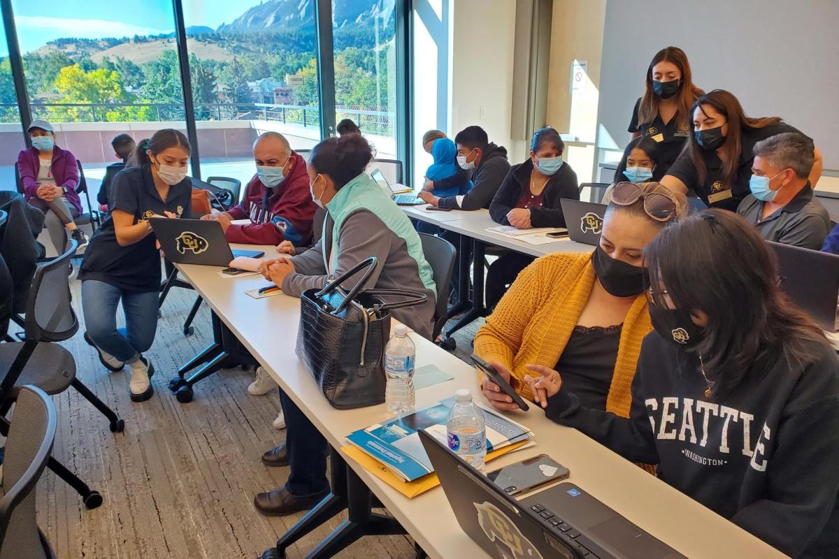 a classroom full of PCDP students and their parents working on financial aid applications during a Saturday academy
