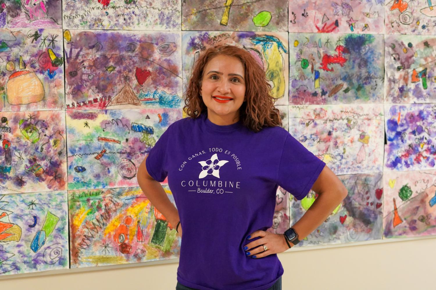 Lisa Martinez, principal at Columbine Elementary and PCDP alumna smiling in front of student art