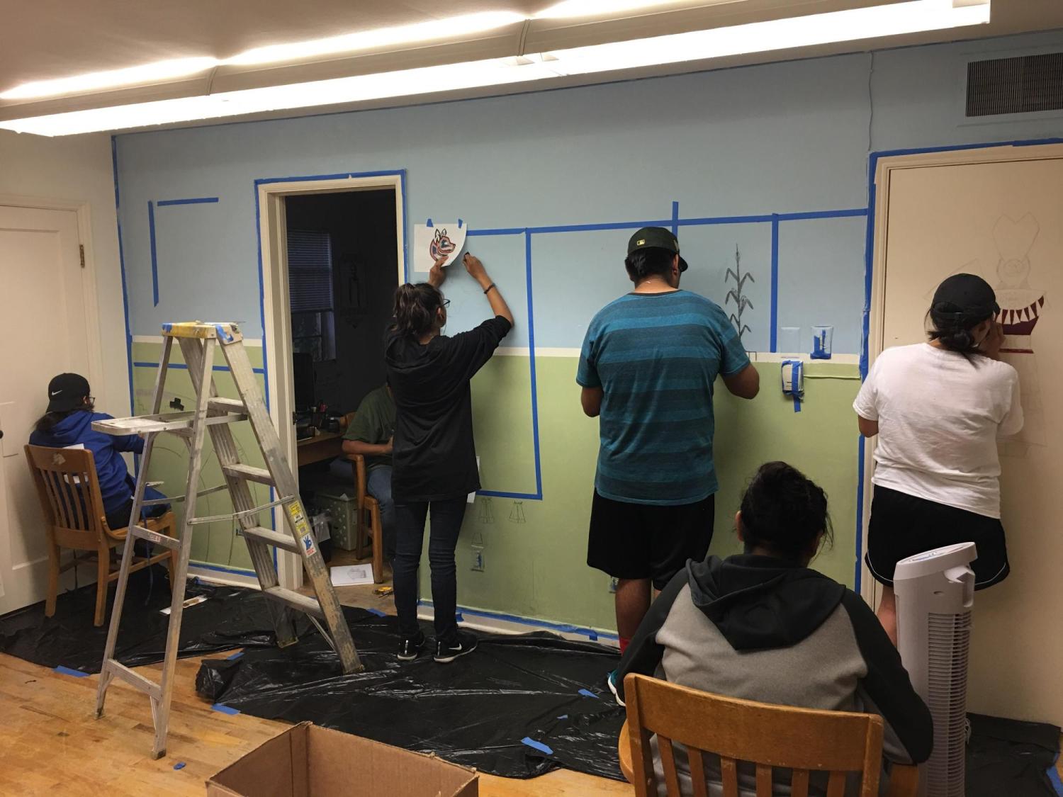CUUB students painting artwork on a wall