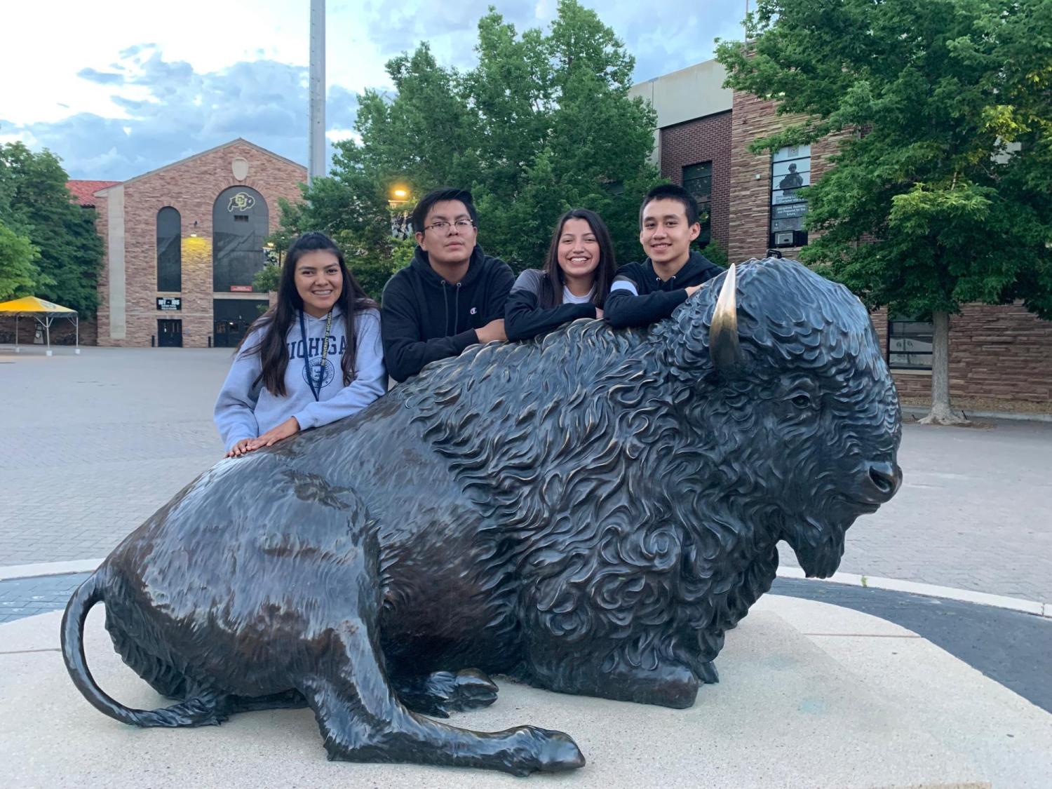 4 CUUB students posing behind the Ralphie statue in front of Folsom field
