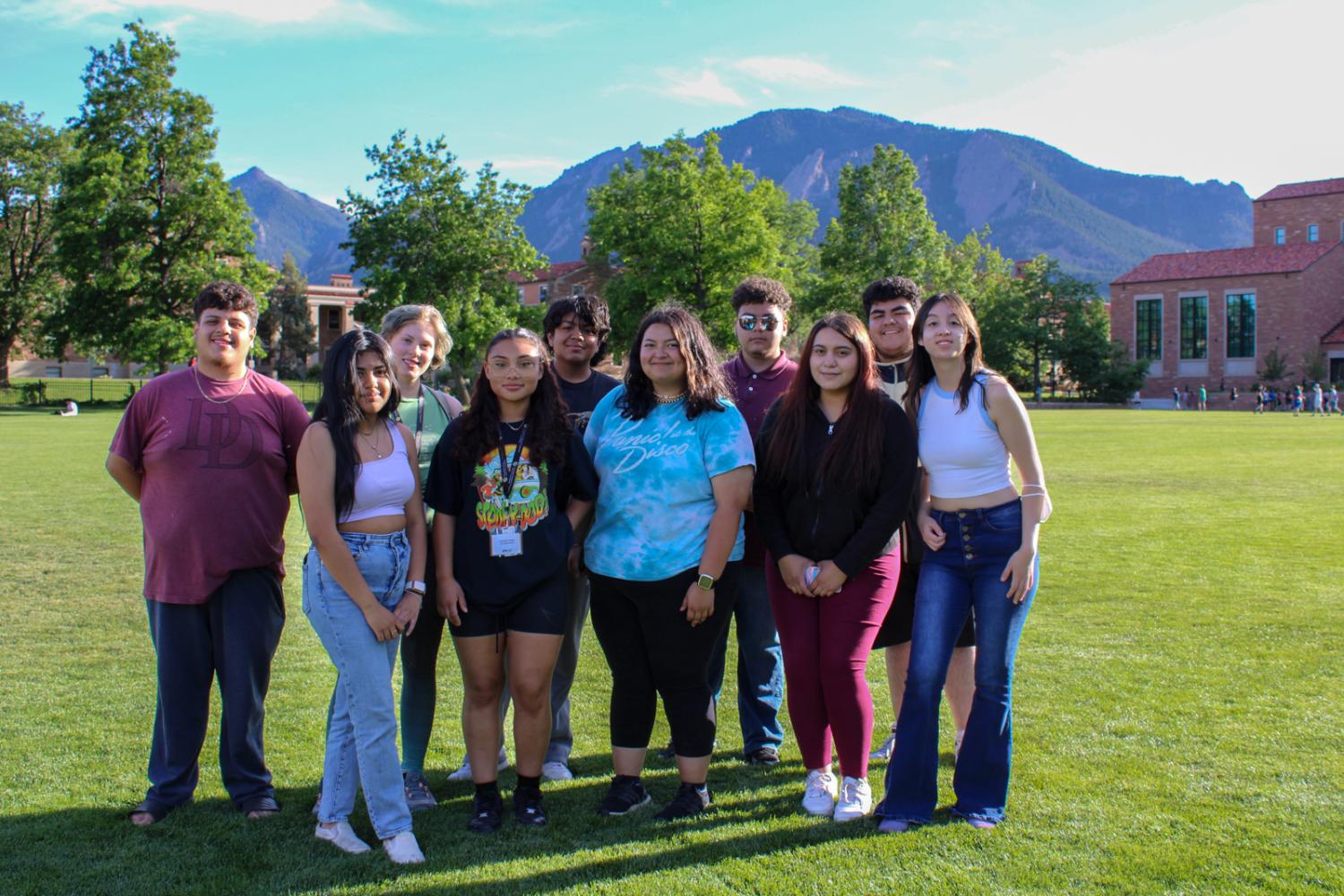 a group of students standing together in a field on campus
