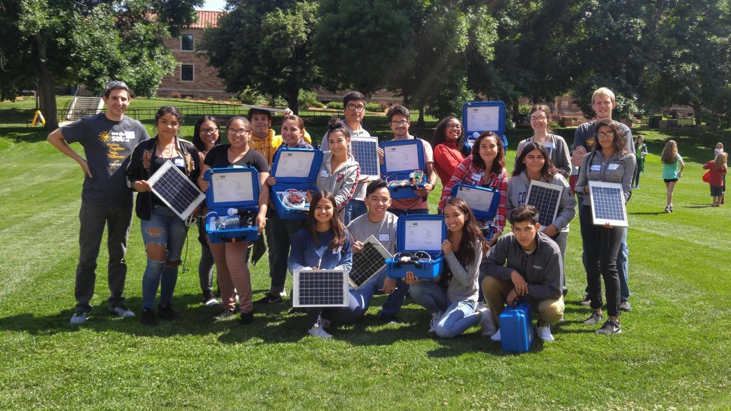 a group of STEM program participants holding the solar panel cases they built