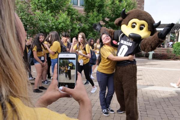 a student posing with Chip the buffalo, CU's costumed mascot