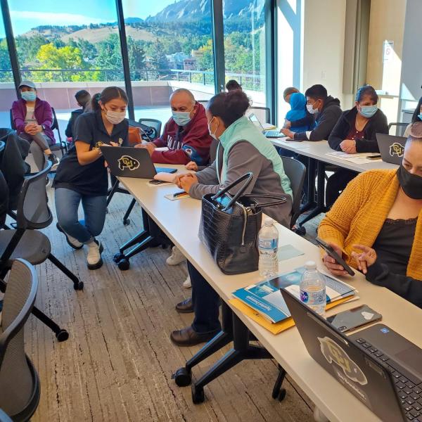 a group of students and parents working on financial aid applications during a Saturday academy