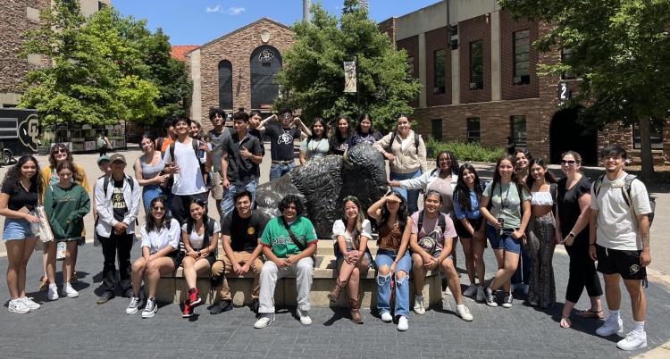 Precollege students posing for a photo in front of Folsom Field.