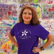 Lisa Martinez, principal at Columbine Elementary and PCDP alumna smiling in front of student art